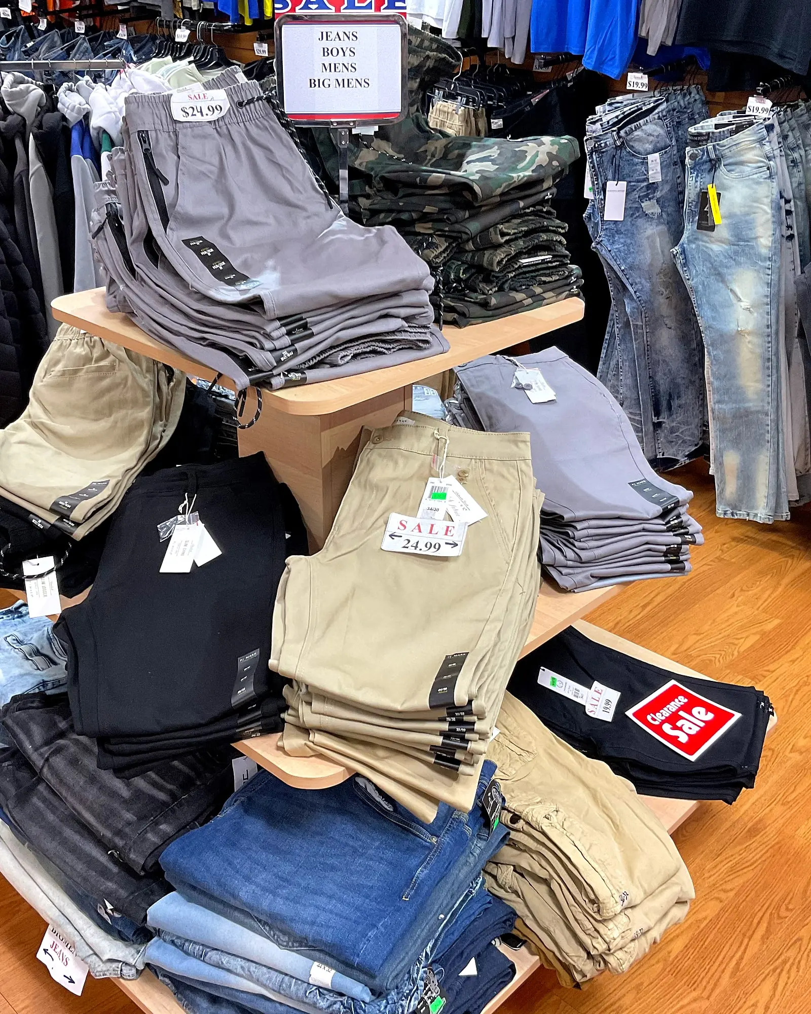 A table of pants and shorts under a sign that reads “Jeans, Boys, Mens, Big Mens”