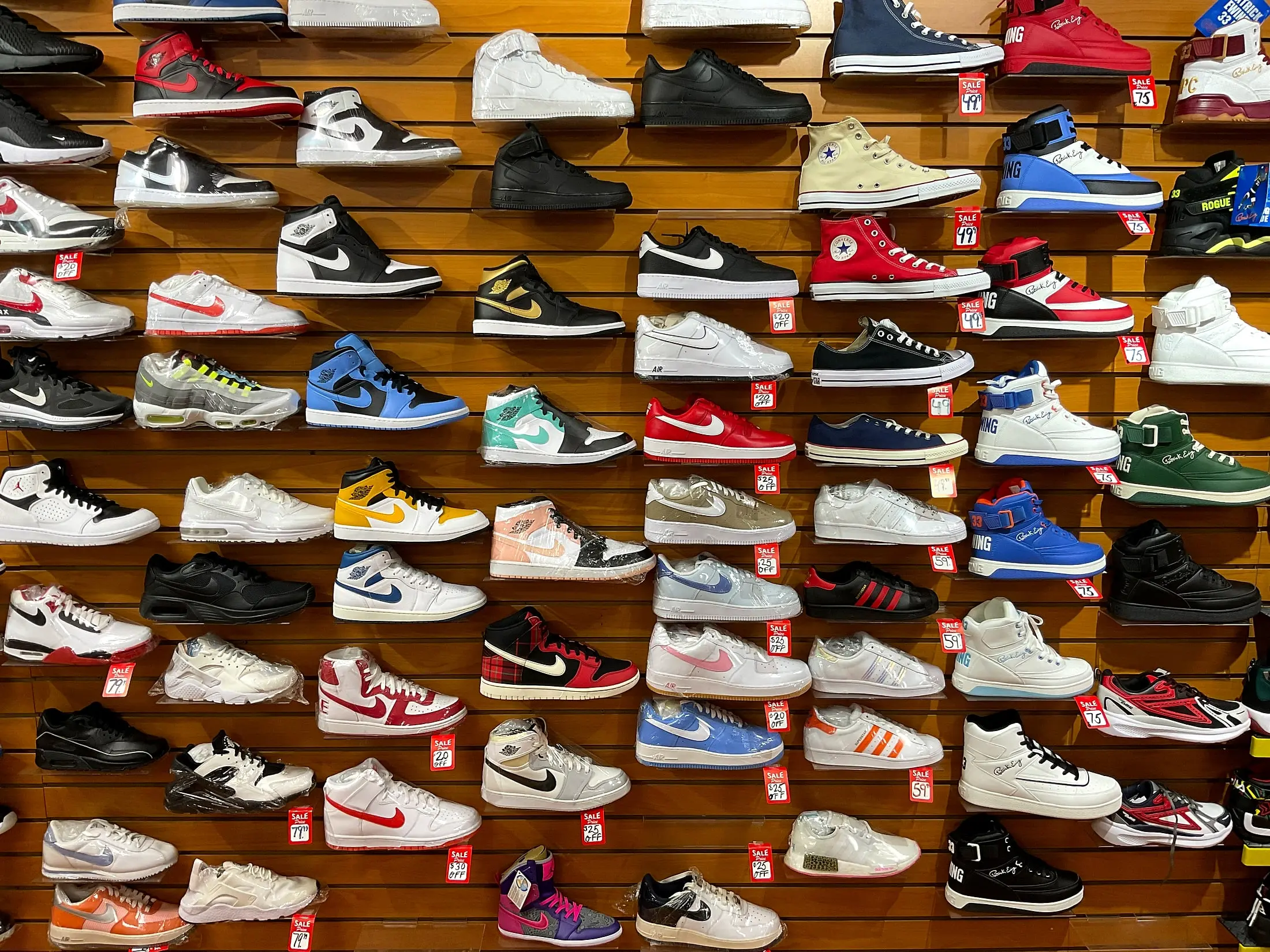 The sneaker wall, with Nike, Jordan, and Converse styles and red sale tags