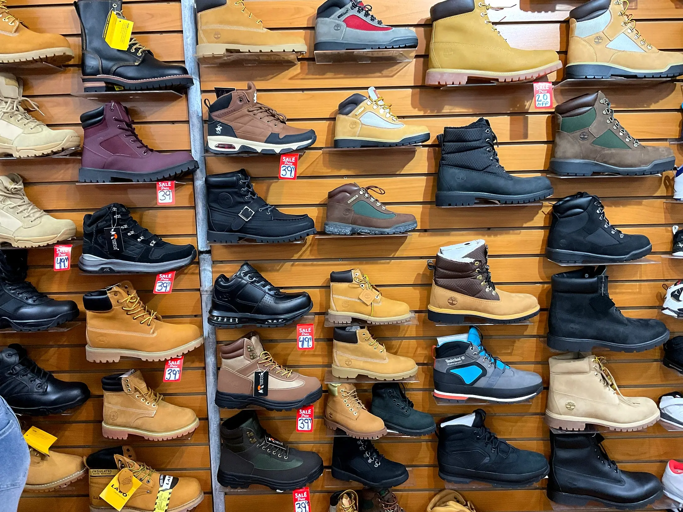 A wall of work boots in wheat, black, and brown leather, with sale tags