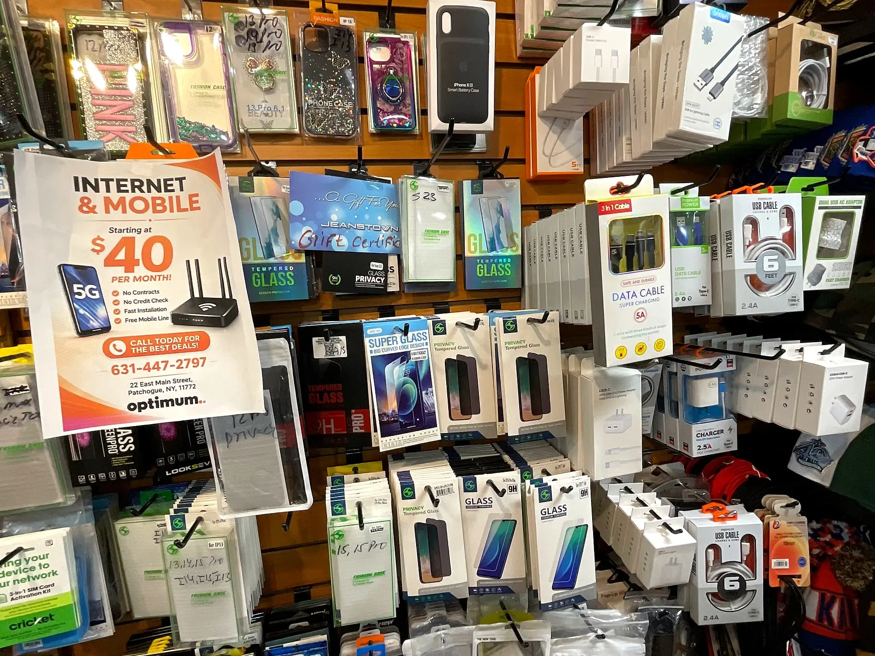 Screen protectors, charging cables, and wall chargers next to an Internet & Mobile flyer